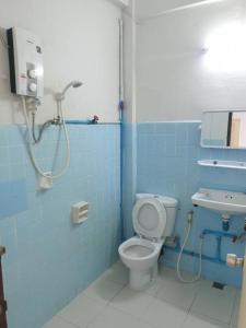 a blue bathroom with a toilet and a sink at SA hotel in Trat