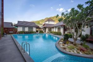 a swimming pool in front of a house at The La-Ngu Boutique in Langu