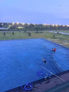a large blue swimming pool with two people in it at Homestay- Phòng nghỉ Lazur Cửa Lò in Giáp Vinh Yên