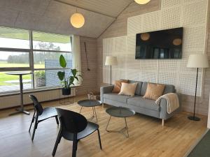 a living room with a couch and chairs and tables at Holiday Close To Beach Golf And Café in Pandrup