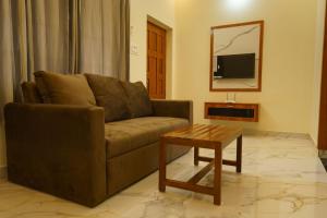 a living room with a couch and a coffee table at Gayathri Nest in Udupi