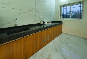 a kitchen with marble counter top and a sink at Gayathri Nest in Udupi +15 photos