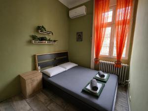 a small bedroom with a bed and a window at Habitat Hostel in Belgrade