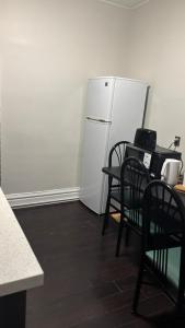 a kitchen with two chairs and a white refrigerator at Casa Toronto in Toronto