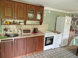 a kitchen with wooden cabinets and a white refrigerator at LeriMari in Mestia