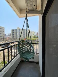 a swing on a balcony with a view of a city at Joy Suites and Hostel in Pune +16 photos