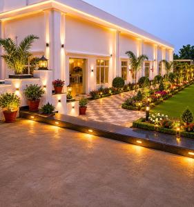 a large white building with lights in a courtyard at Heritage Garden in Bānsjora
