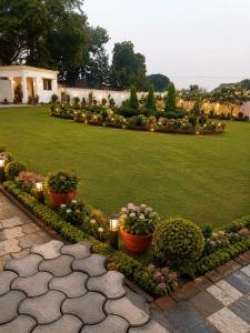 a garden with potted plants and lights on a lawn at Heritage Garden in Bānsjora