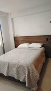 a bedroom with a large bed with two pillows at Terramia Suite in Cabudare