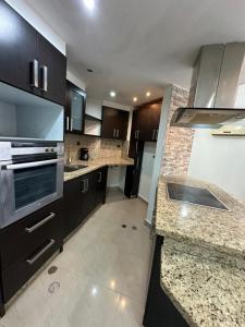 a kitchen with black cabinets and marble counter tops at Terramia Suite in Cabudare