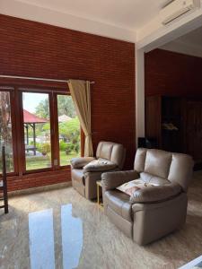 a living room with two couches and a large window at The Mungseng Villa Bali in Singaraja