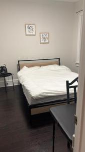 a bedroom with a bed with white sheets and a table at Casa Toronto in Toronto