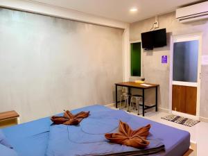 a bedroom with a blue bed with brown pillows on it at Kidthuengpark in Ban Nong Faep