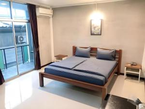 a bedroom with a bed and a large window at Kidthuengpark in Ban Nong Faep