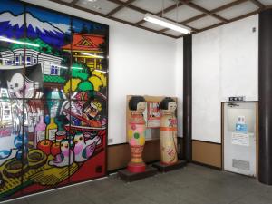a room with a wall with paintings on it at 駅舎泊ラッセルイン in Hirakawa