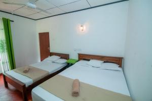 two beds in a room with two beds sidx sidx sidx sidx at Zenvora Rainforest Villa in Deniyaya +13 photos
