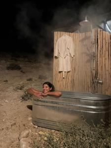 a woman is taking a bath in a bath tub at DESERT Ezuz in ‘Ezuz
