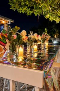 a table with candles and flowers in vases on it at Jul Rick House Guesthouse in Sandton +56 photos