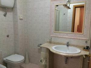 W łazience znajduje się umywalka, toaleta i lustro. w obiekcie Hotel Almas w Capaccio-Paestum
