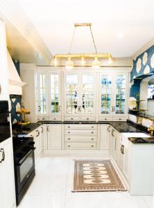 a kitchen with white cabinets and a chandelier at Jul Rick House Guesthouse in Sandton