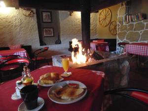 a table with two plates of food and orange juice at Rural Arco Iris in Cuenca