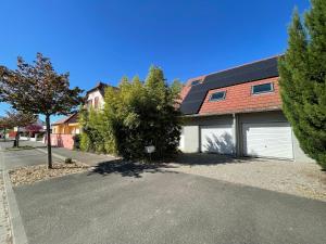 a house with two garage doors on a street at Maisons avec terrasse et parking in Colmar