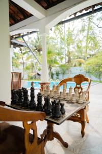 a chess board on a table next to a chair at Lucas Hotel in Kosgoda