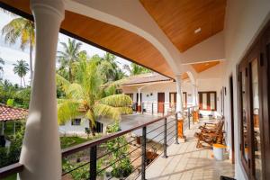 an outdoor balcony with a view of a house at Lucas Hotel in Kosgoda
