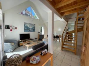 a living room with a couch and a tv at Maisons avec terrasse et parking in Colmar