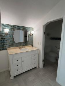 a bathroom with a sink and a mirror at Two Bedroom Beach Apartment in Sunset Beach +18 photos