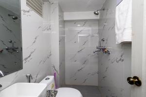 a white bathroom with a shower and a toilet at Hotel Outfitter Nepal in Kathmandu +55 photos