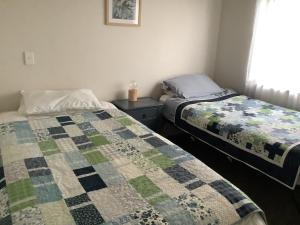 two beds sitting next to each other in a bedroom at Relaxing Beach Side House in Porirua