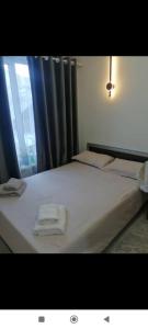 a bedroom with a bed with two towels on it at Modern Homestay in Arslanbob