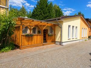 a house with a wooden fence and a driveway at Spreewald Błota Jéwa Ferienwohnung mit Terrasse und Parkplatz in Lübbenau +8 photos