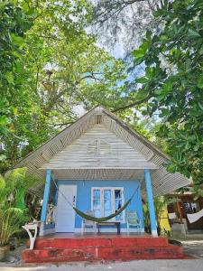 a small blue house with a hammock in front of it at Longbeach Kohphayam in Ko Phayam