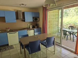a kitchen with a table and chairs and a dining room at Cottage Mansart piscine tout équipé in Chaveignes
