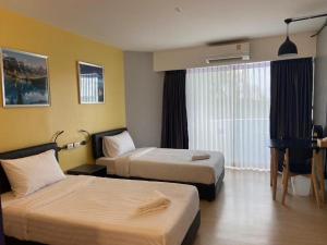 a hotel room with two beds and a window at DLUXX THAMMASAT in Ban Bang Phut (3)