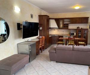 a living room with a couch and a television at Affittacamere Ramina in San Giuseppe