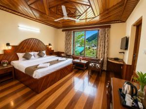 a bedroom with a large bed and a large window at Royal Kalinga Cottage near volvo bus stand, Manali - Best Property of Manali 2025-26 in Manāli