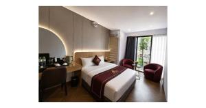 a hotel room with a bed and a desk and a window at Rosy Hotel 8 in Yên Lô