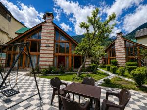 a patio with a table and chairs and a house at Royal Kalinga Cottage near volvo bus stand, Manali - Best Property of Manali 2025-26 in Manāli