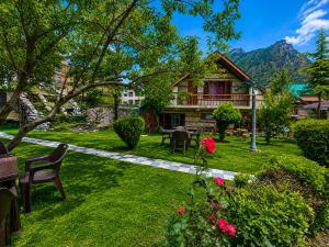 a garden with a house and a table and chairs at Royal Kalinga Cottage near volvo bus stand, Manali - Best Property of Manali 2025-26 in Manāli +64 photos