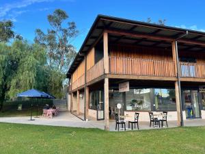 a building with tables and chairs in a park at Bridge Motor Inn Tocumwal in Tocumwal