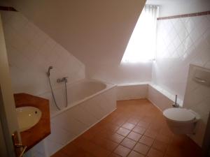 a bathroom with a tub and a toilet and a sink at Hotel Freihof in Wiesloch