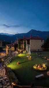 a large yard with a building and a pizza at Village Inn in Ano Chora