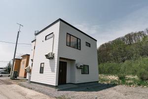 a small white house on the side of a road at AOI Villa Biei in Biei