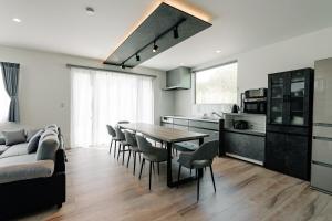 a kitchen and living room with a table and chairs at AOI Villa Biei in Biei