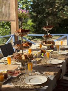 a table with food and plates and glasses of orange juice at La Maison du Chevalier - Chambres et tables d'hôtes in Marat