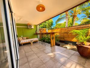 a balcony of a house with a table and a couch at Cocon Romantique in La Saline les Bains