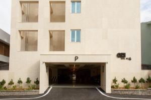 a large white building with a parking garage at Hotel Ieum Mokpo peace square branch in Mokpo